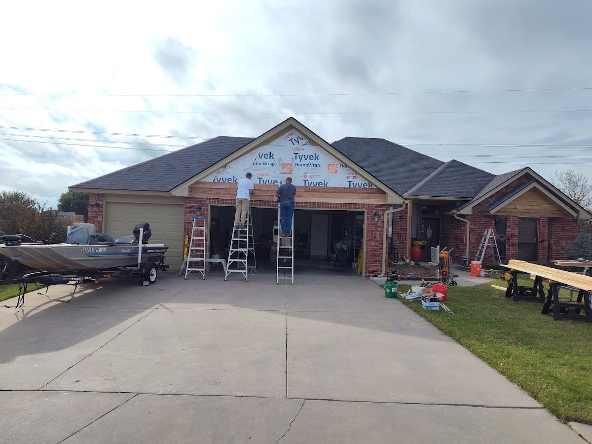 Crew installing Tyvek house wrap across full front of brick home