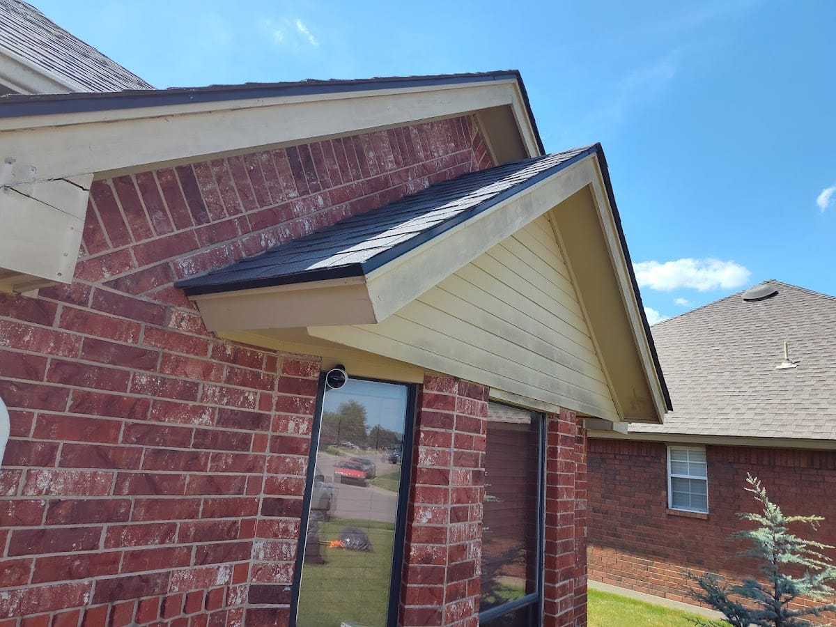 Finished gable detail of red brick home with white soffit