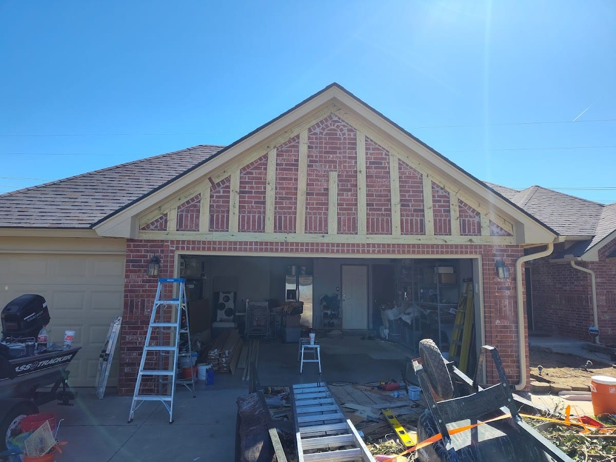 New wood-framed gable extension on brick home for garage addition