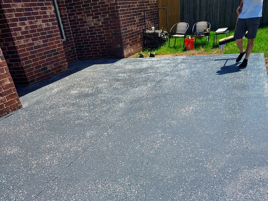 Back patio finished with a grey epoxy coating and colour flake broadcast, chairs against the fence